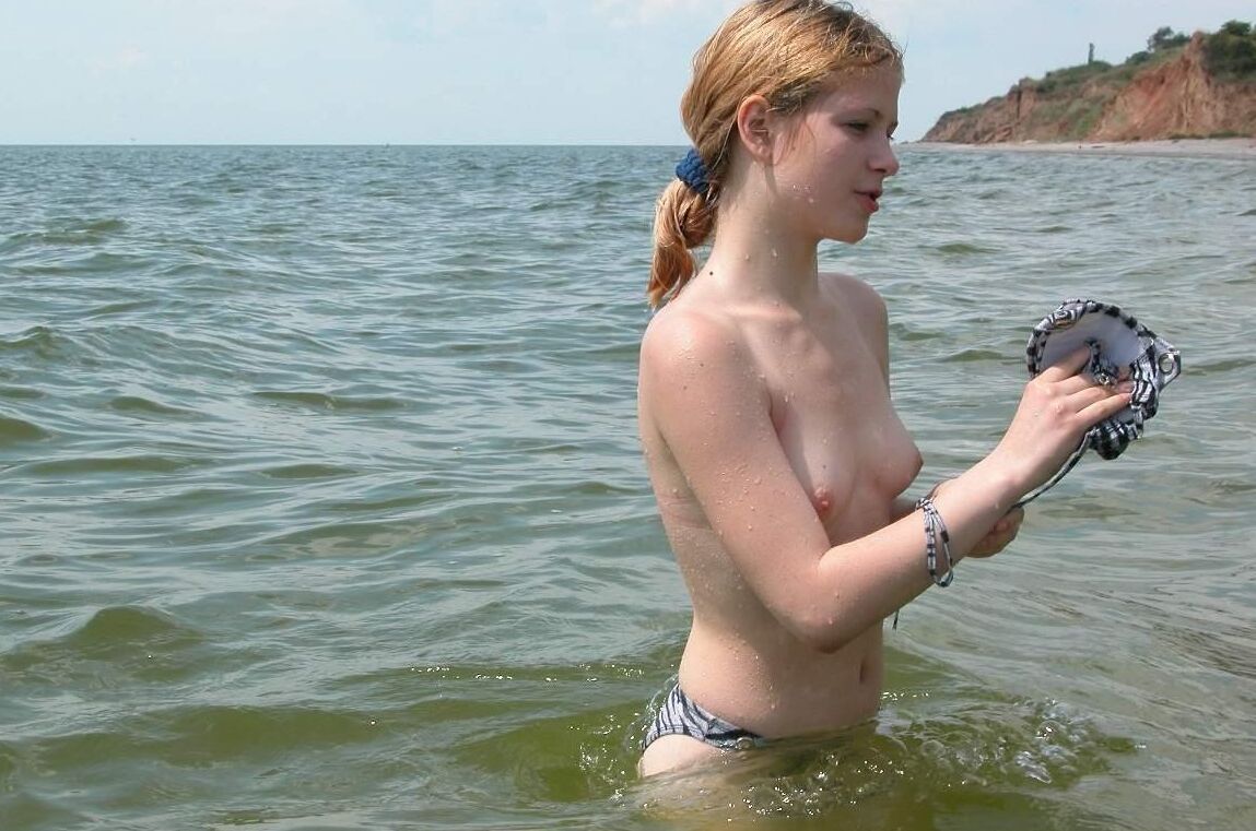Blonde milf nudist strips down naked at a public beach