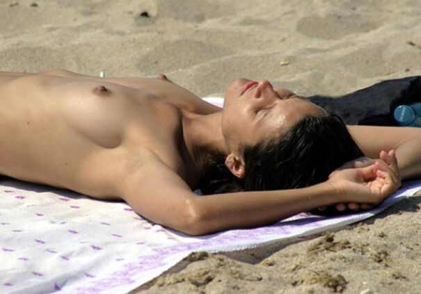 Blonde milf nudist strips down naked at a public beach