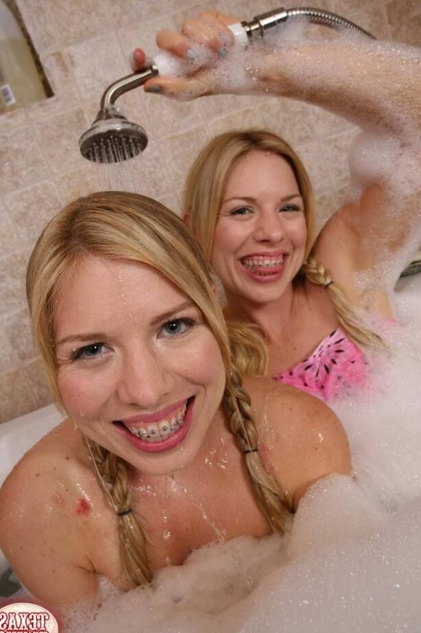 Two cute blonde twin teen sisters getting all wet