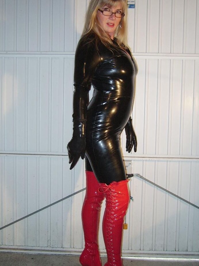 Fetish wife wearing tight latex catsuit and red heeld boots