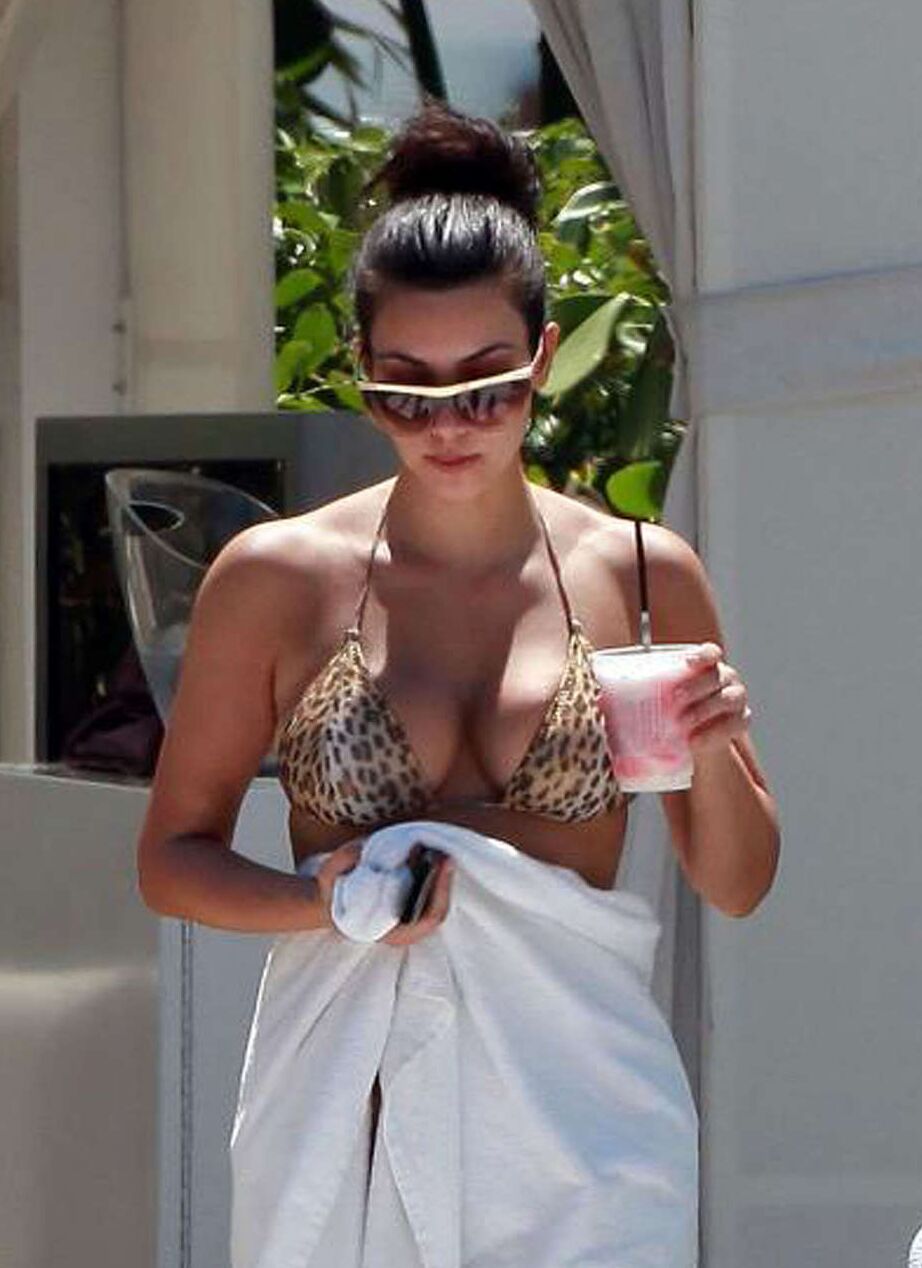 Kim Kardashian exposing her sexy body and huge boobs in bikini on pool
