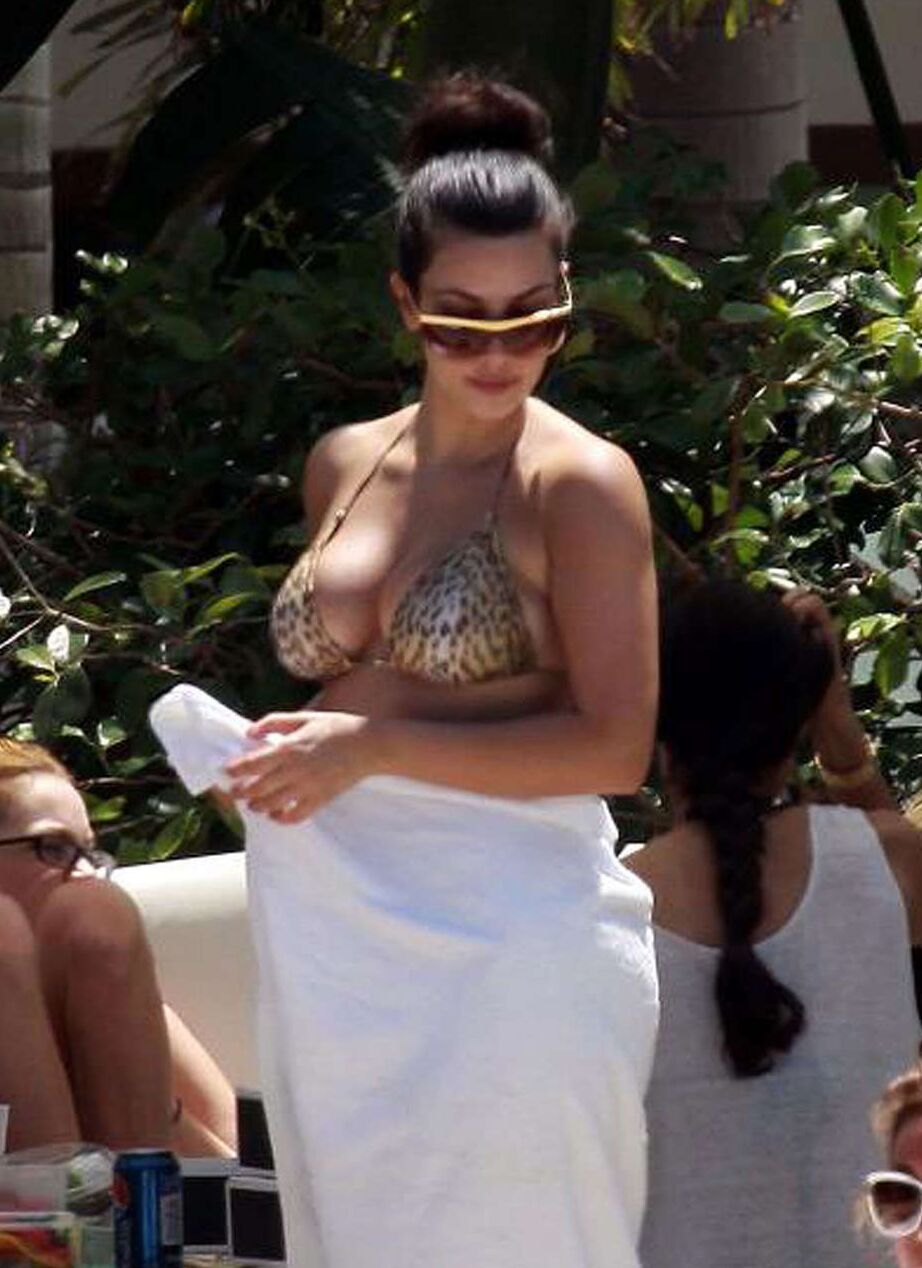 Kim Kardashian exposing her sexy body and huge boobs in bikini on pool