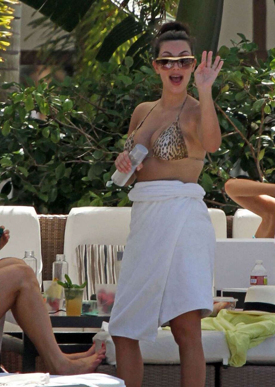 Kim Kardashian exposing her sexy body and huge boobs in bikini on pool