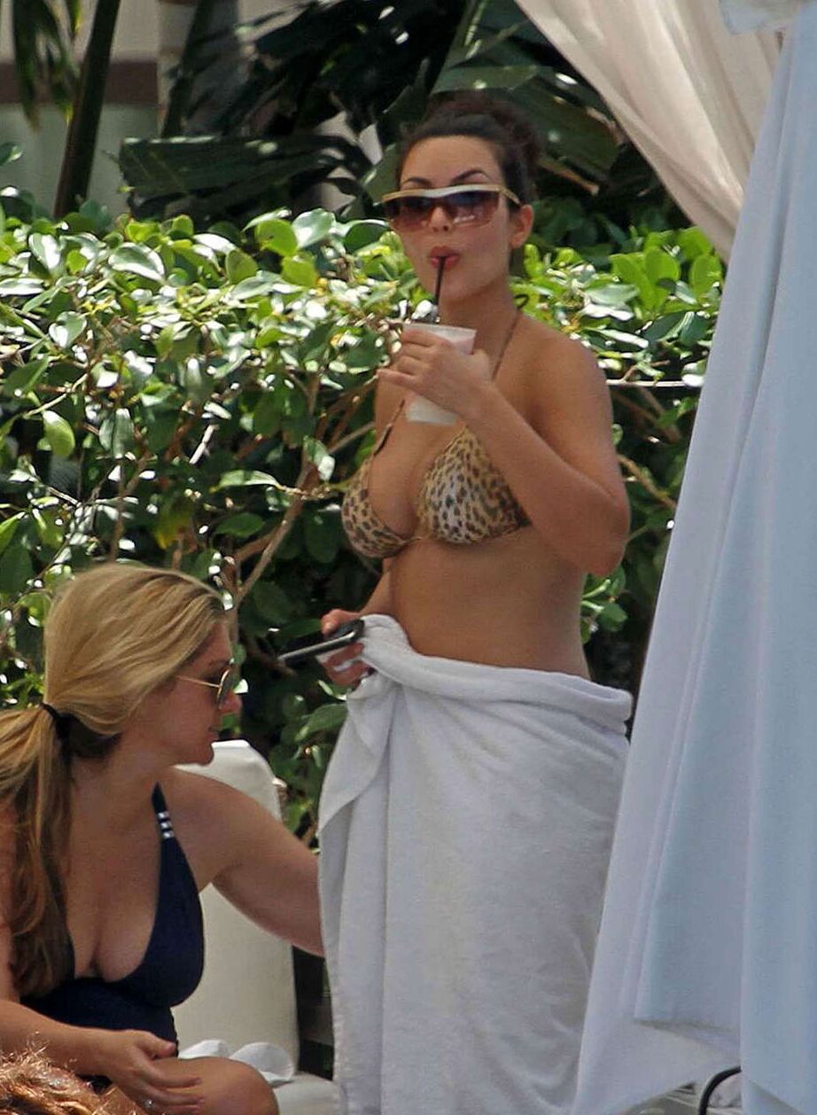 Kim Kardashian exposing her sexy body and huge boobs in bikini on pool