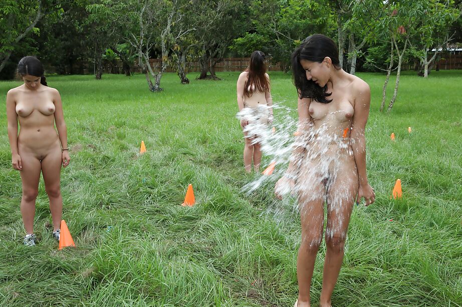 Pretty naked lesbians are standing naked and showing their bodies outdoor