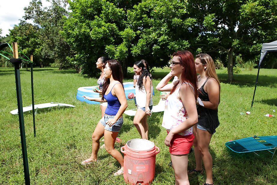 Pretty naked lesbians are standing naked and showing their bodies outdoor