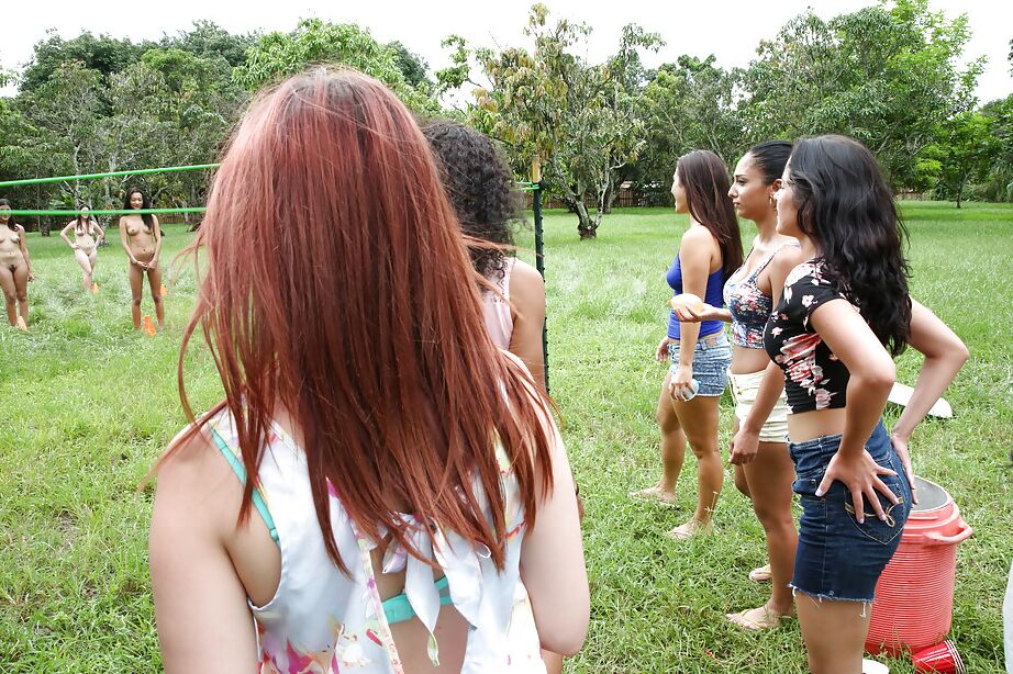 Pretty naked lesbians are standing naked and showing their bodies outdoor