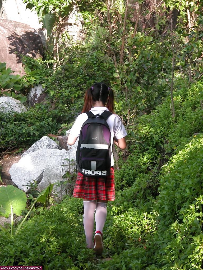 12P Adorable Asian shemale schoolgirl reading a book outdoors and spreading