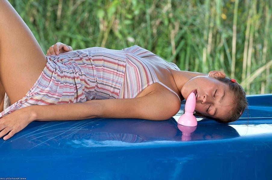 17P Young adorable brunette babe toying herself outdoors on the car