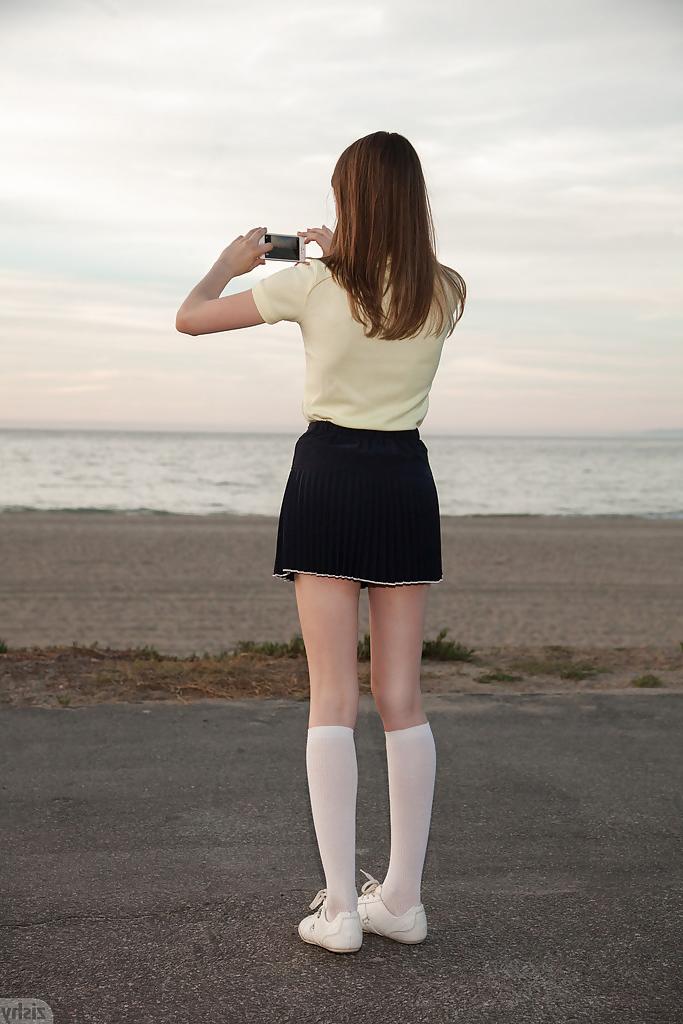 12P Skinny brunette teen Audrey Star posing in a skimpy skirt outdoors