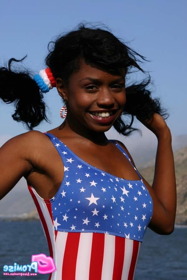 15P Ebony teen in bathing suit strips by the ocean