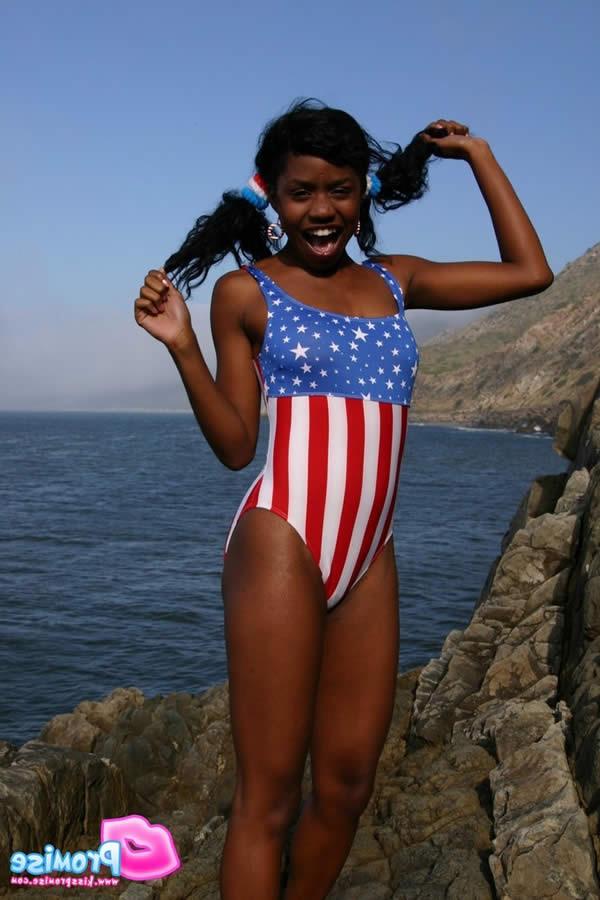 15P Ebony teen in bathing suit strips by the ocean