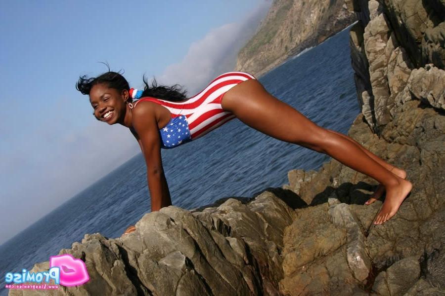 15P Ebony teen in bathing suit strips by the ocean