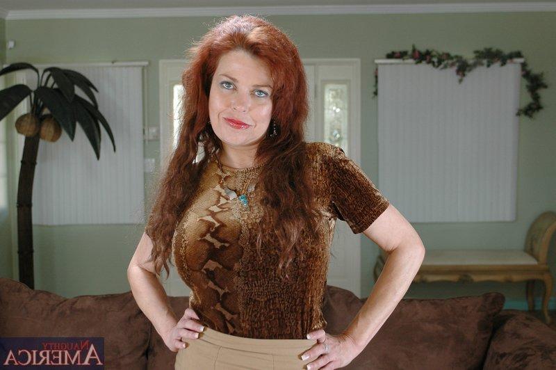16P Redheaded mature Susan Evans denudes huge tits from sexy lingerie