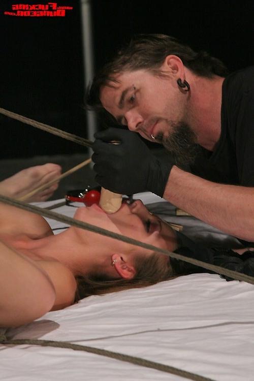 15P Excited chick in bondage act and fucked by two males
