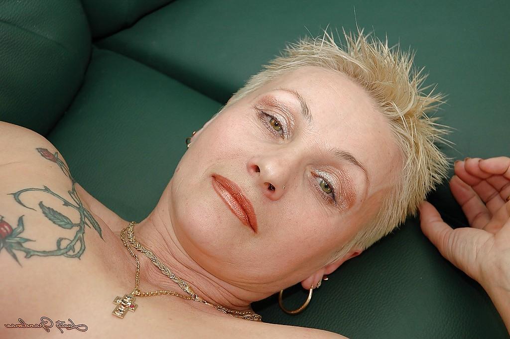 16P Short haired tattooed granny with pierced nipples taking off her lingerie