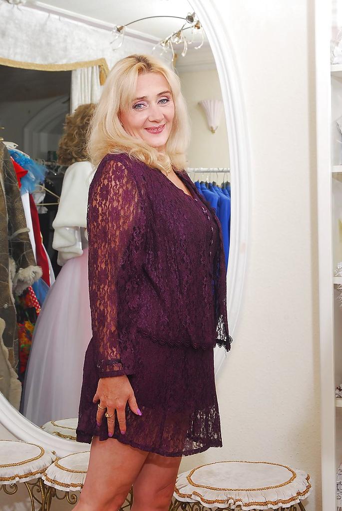 16P Lusty mature blonde in high-heeled boots reveals her jugs and bushy cunt