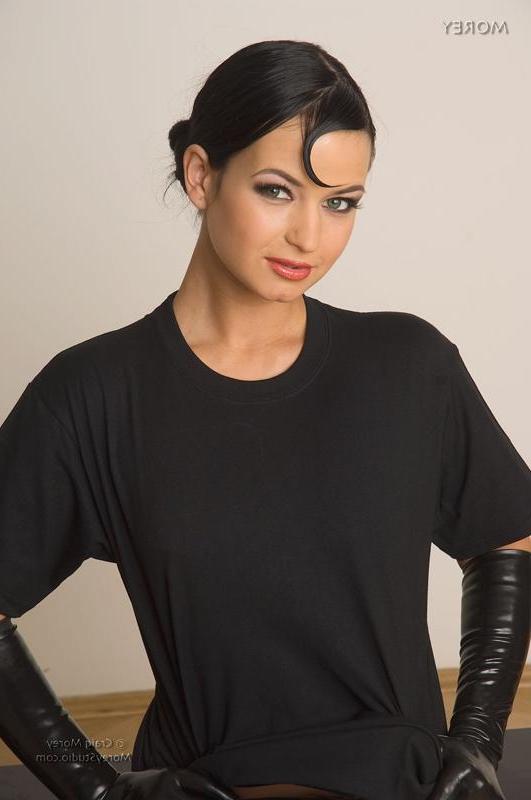 11P Brunette model Nea poses in her latex boots and gloves