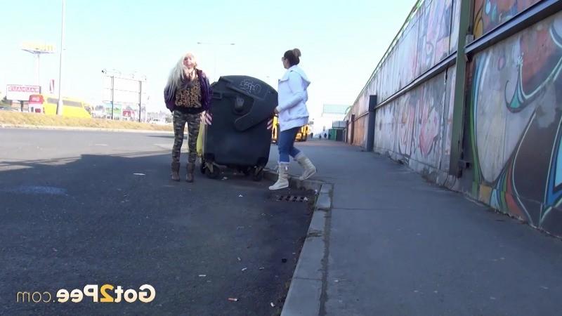 15P Two girlfriends piss in public next to bus stop