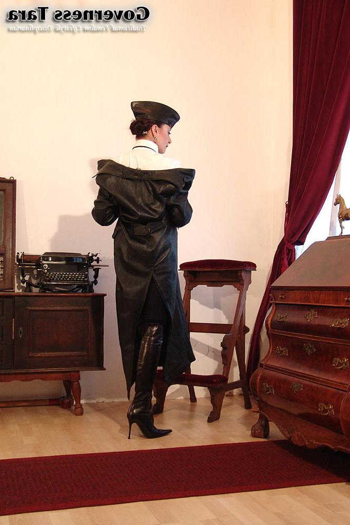 20P Twisted corsetted domina poses in spike heel leather boots