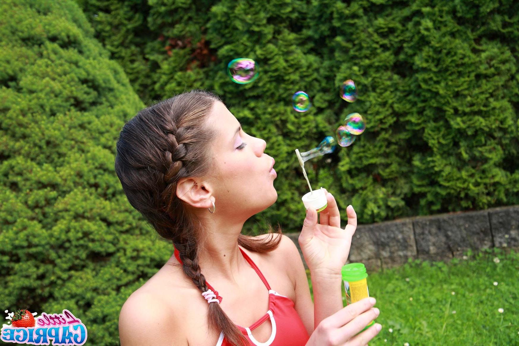 16P Teen schoolgirl blowing bubbles outside