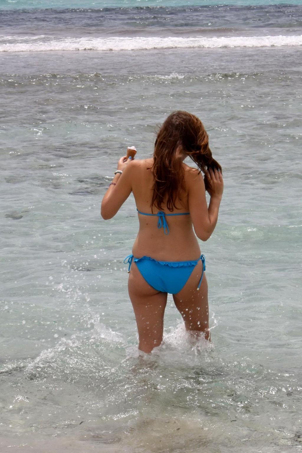 16P Busty Imogen Thomas in blue bikini eating an ice cream on a Spanish beach