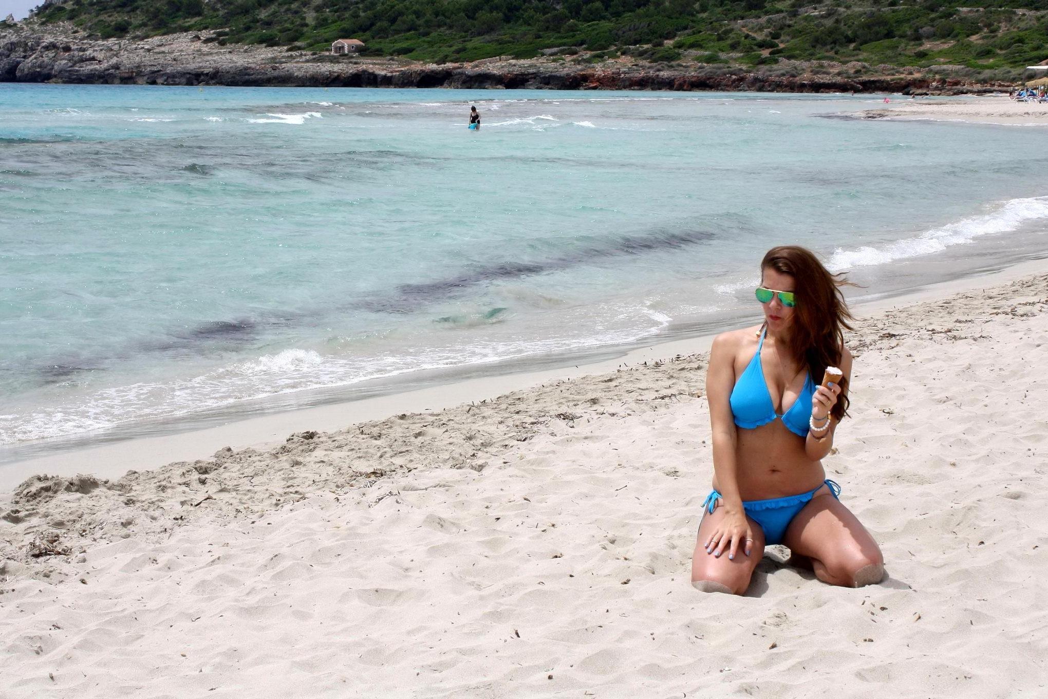 16P Busty Imogen Thomas in blue bikini eating an ice cream on a Spanish beach