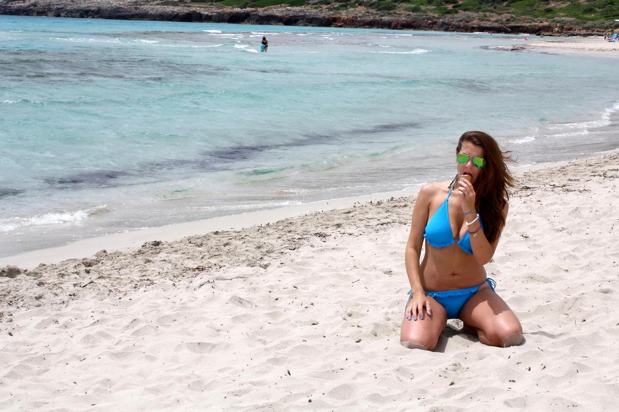 16P Busty Imogen Thomas in blue bikini eating an ice cream on a Spanish beach