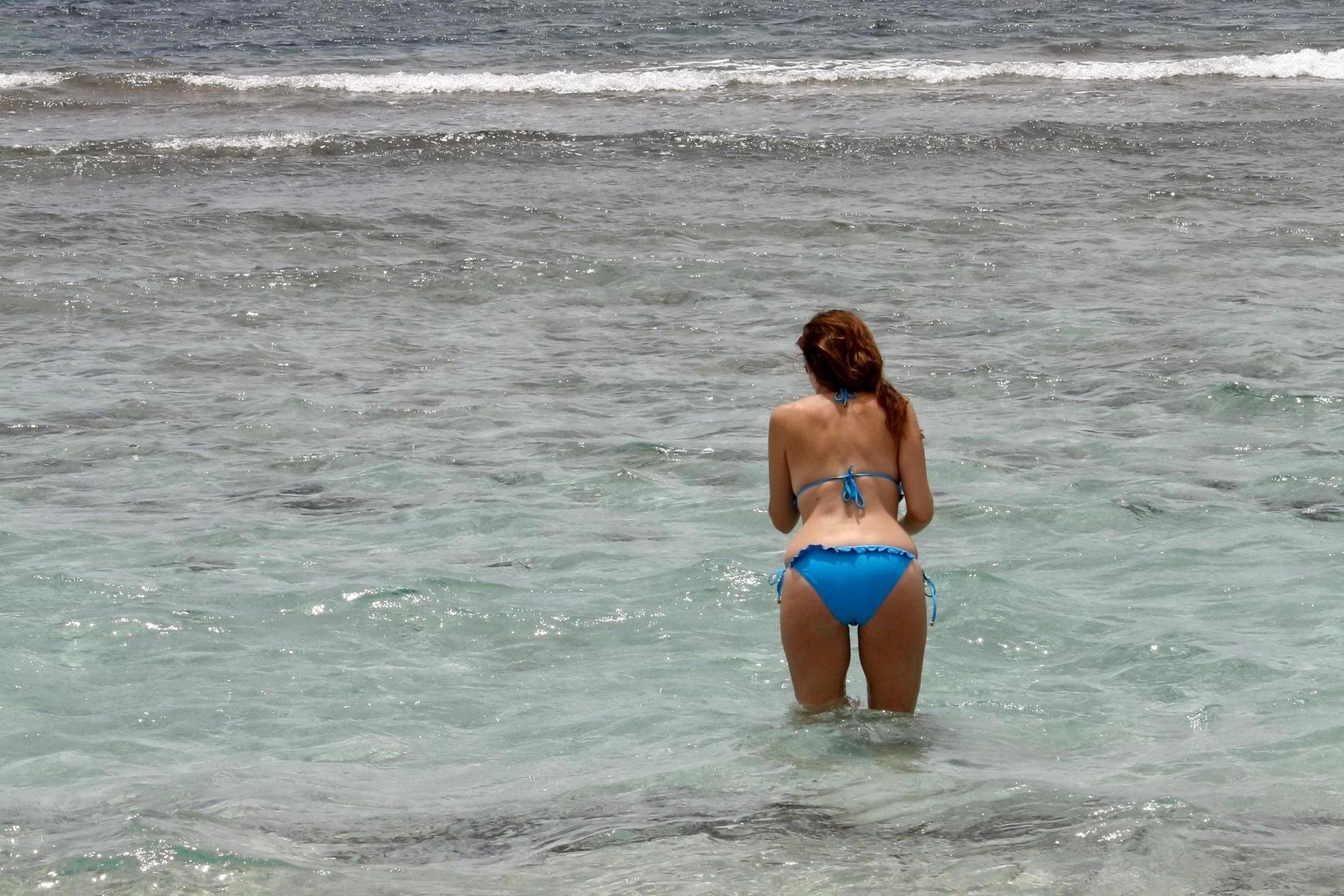16P Busty Imogen Thomas in blue bikini eating an ice cream on a Spanish beach
