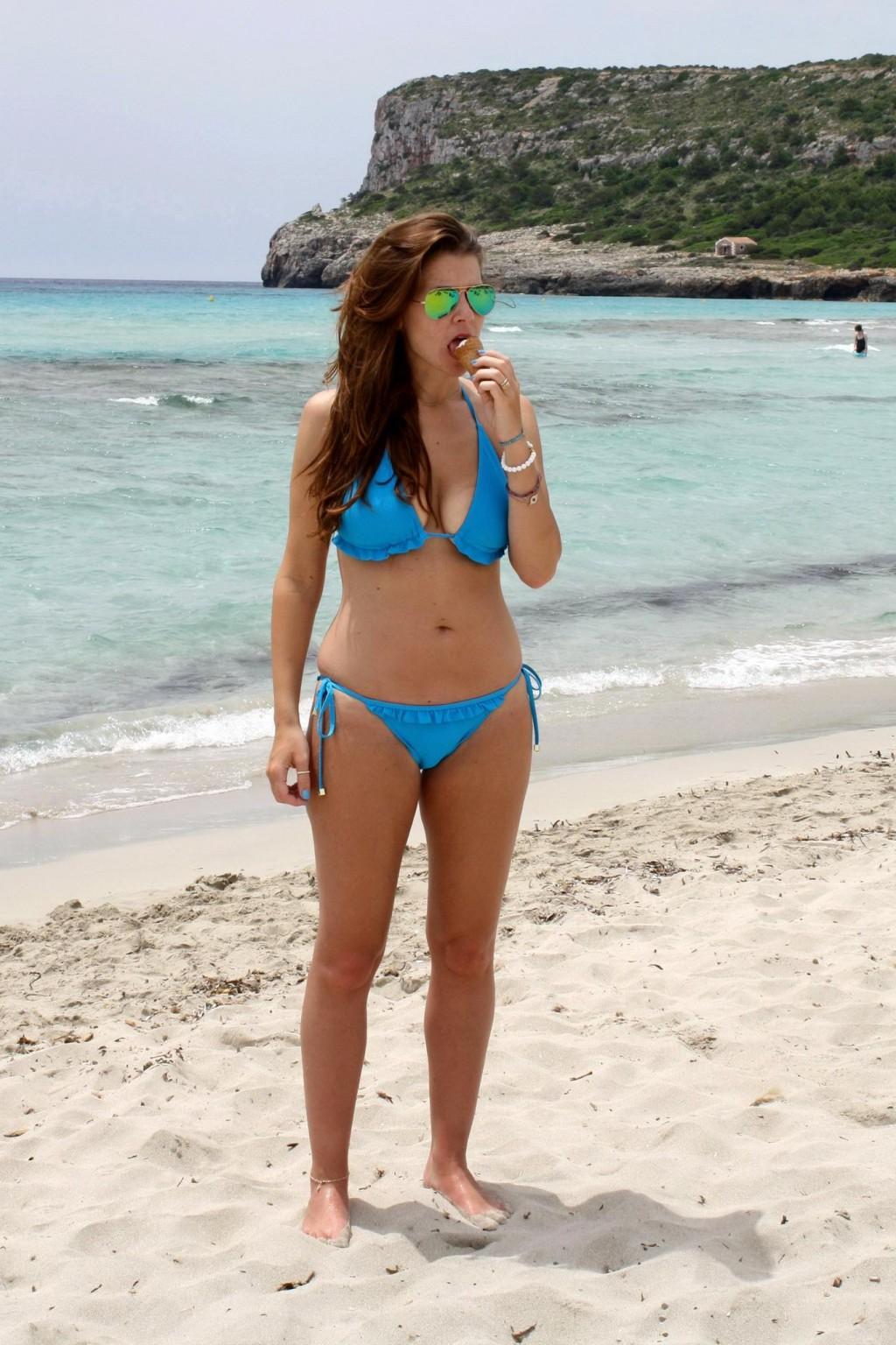 16P Busty Imogen Thomas in blue bikini eating an ice cream on a Spanish beach