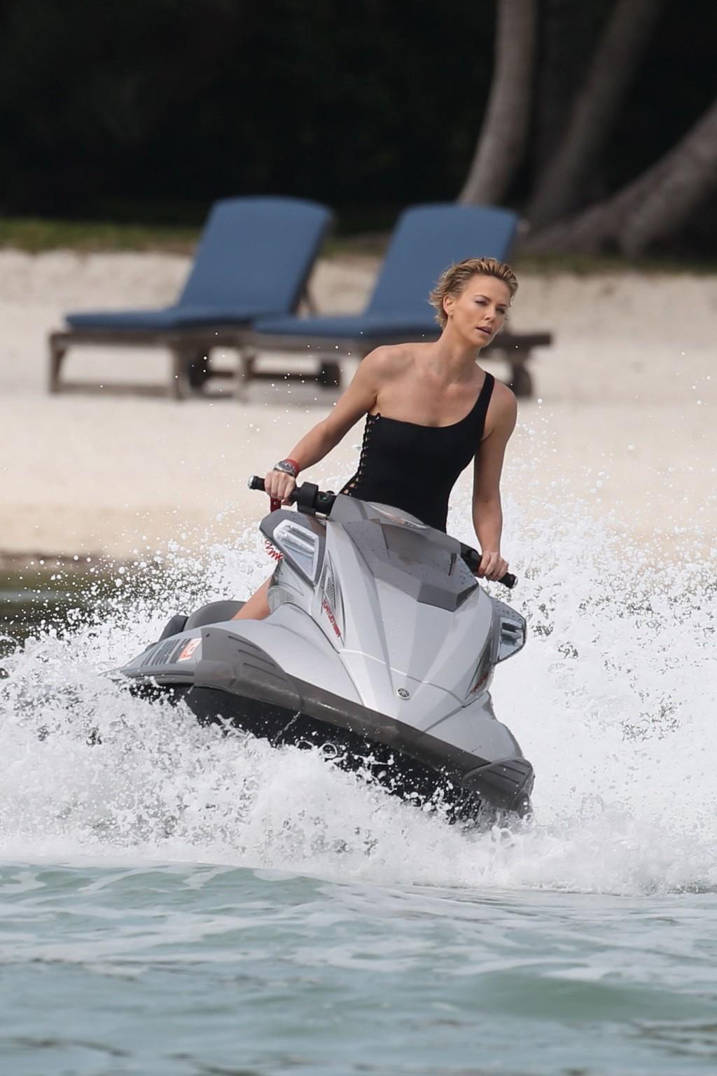 16P Charlize Theron jet skiing in black monokini during the photoshoot in Miami Beac