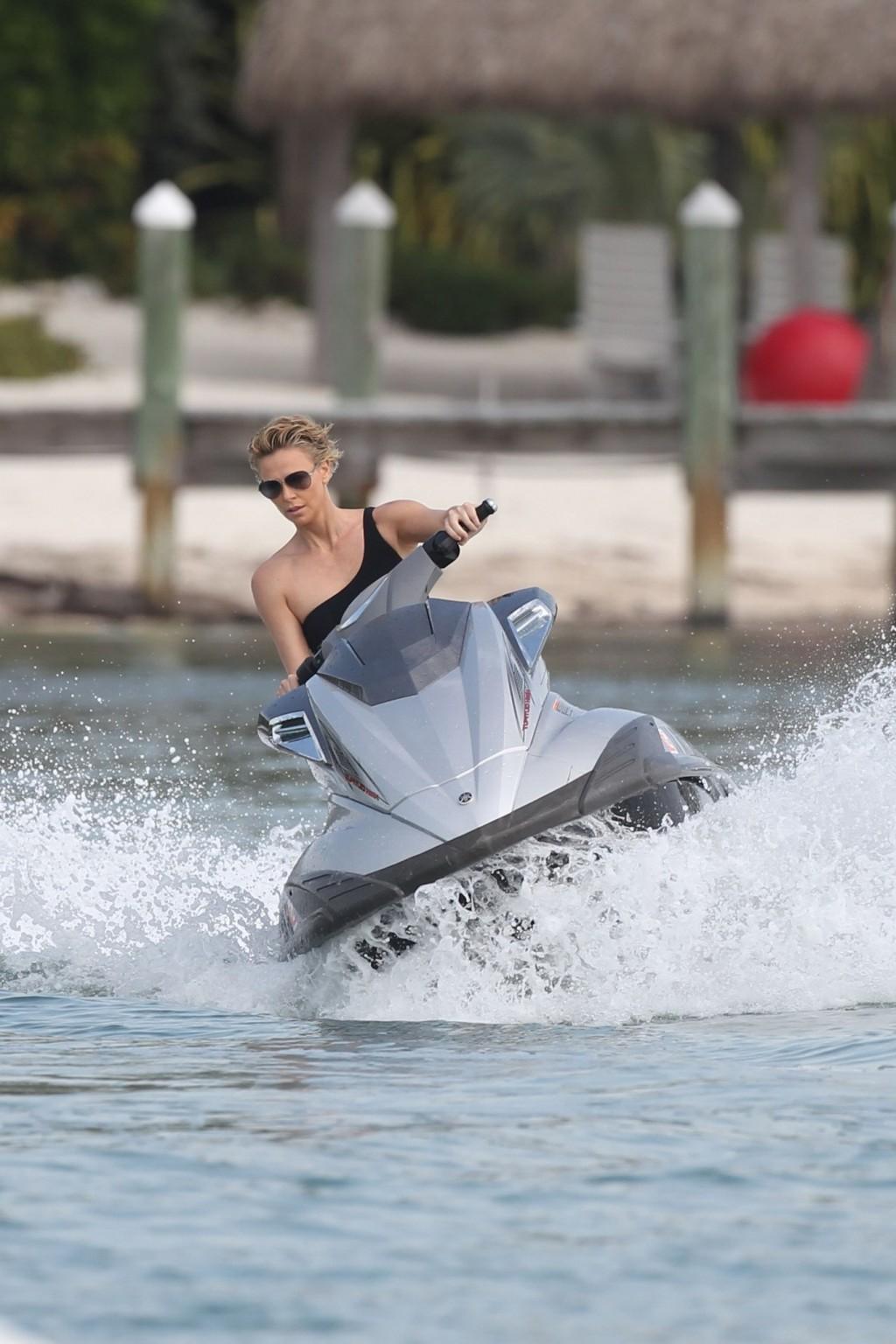 16P Charlize Theron jet skiing in black monokini during the photoshoot in Miami Beac