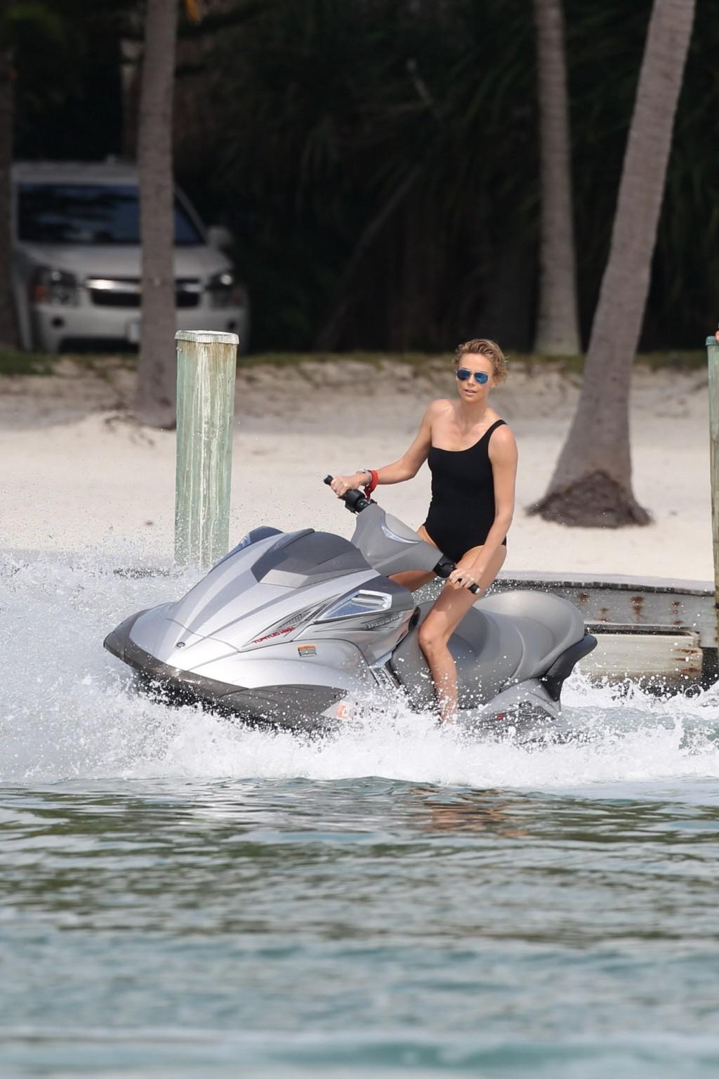 16P Charlize Theron jet skiing in black monokini during the photoshoot in Miami Beac