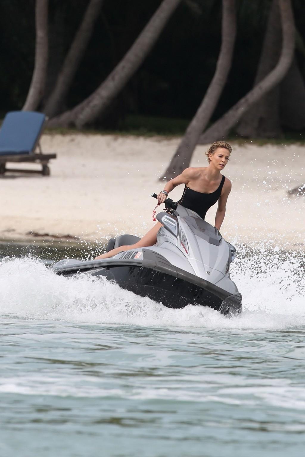 16P Charlize Theron jet skiing in black monokini during the photoshoot in Miami Beac