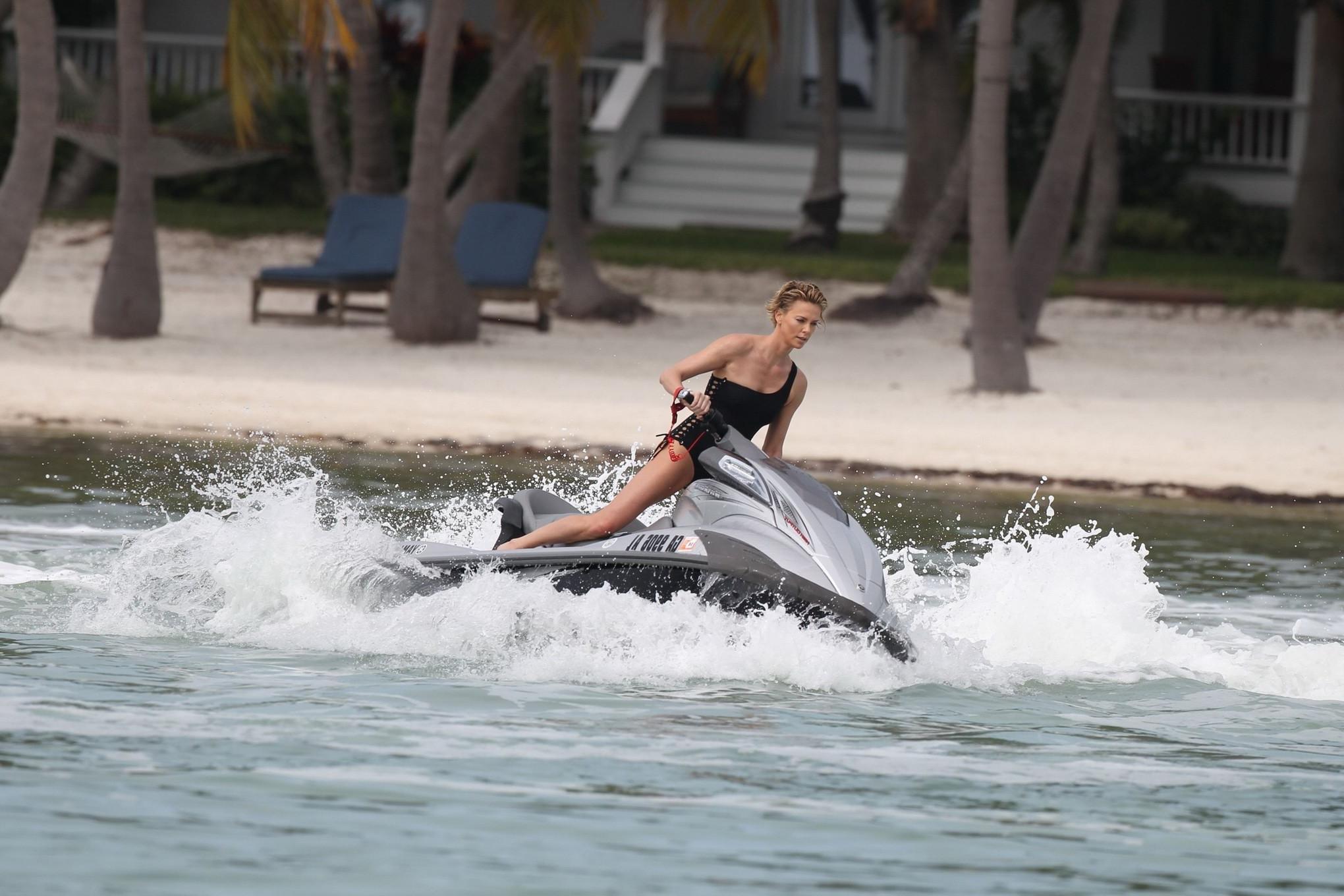 16P Charlize Theron jet skiing in black monokini during the photoshoot in Miami Beac