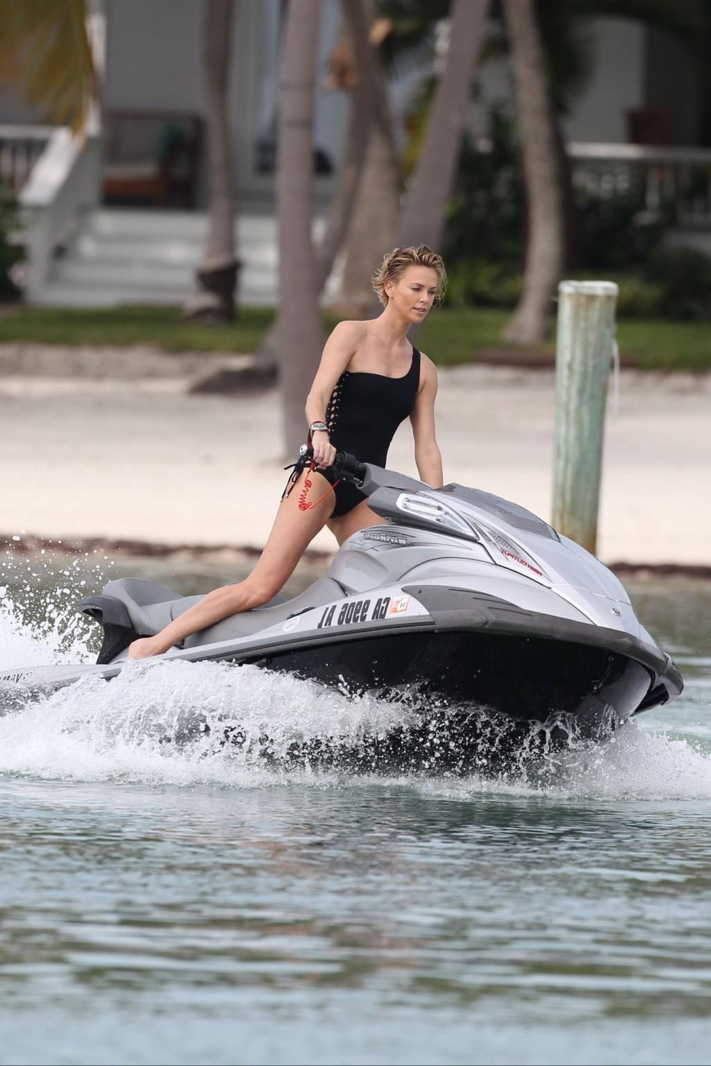 16P Charlize Theron jet skiing in black monokini during the photoshoot in Miami Beac