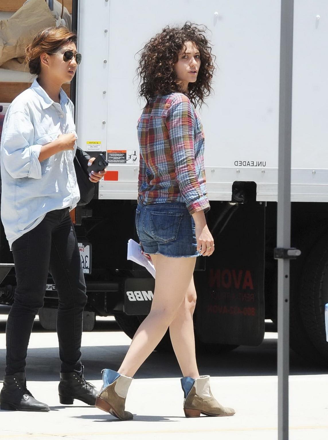 16P Emmy Rossum wearing denim shorts and some crazy hair on the set of Comet in LA