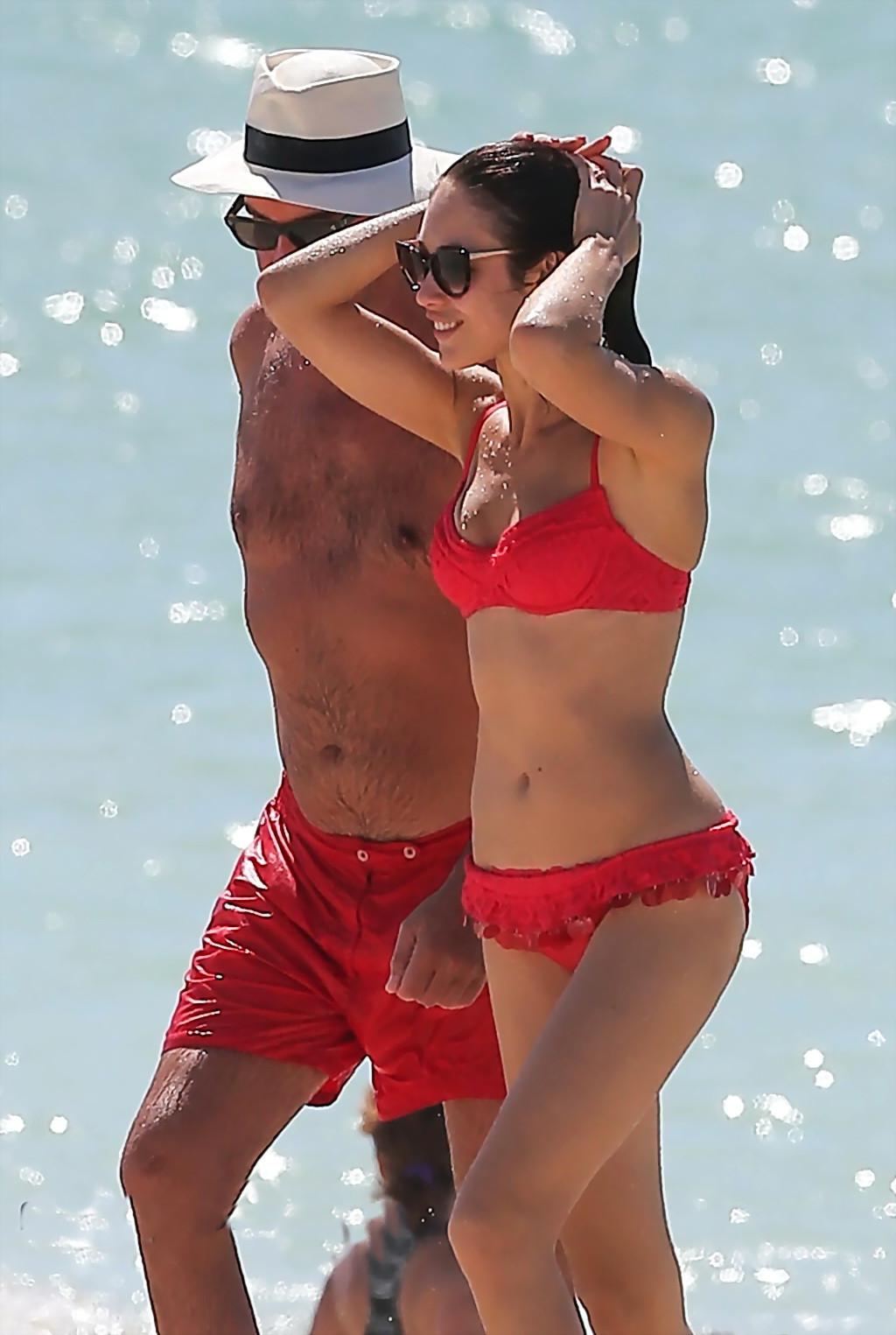 6P Olga Kurylenko caught all wet on the beach wearing skimpy red two piece