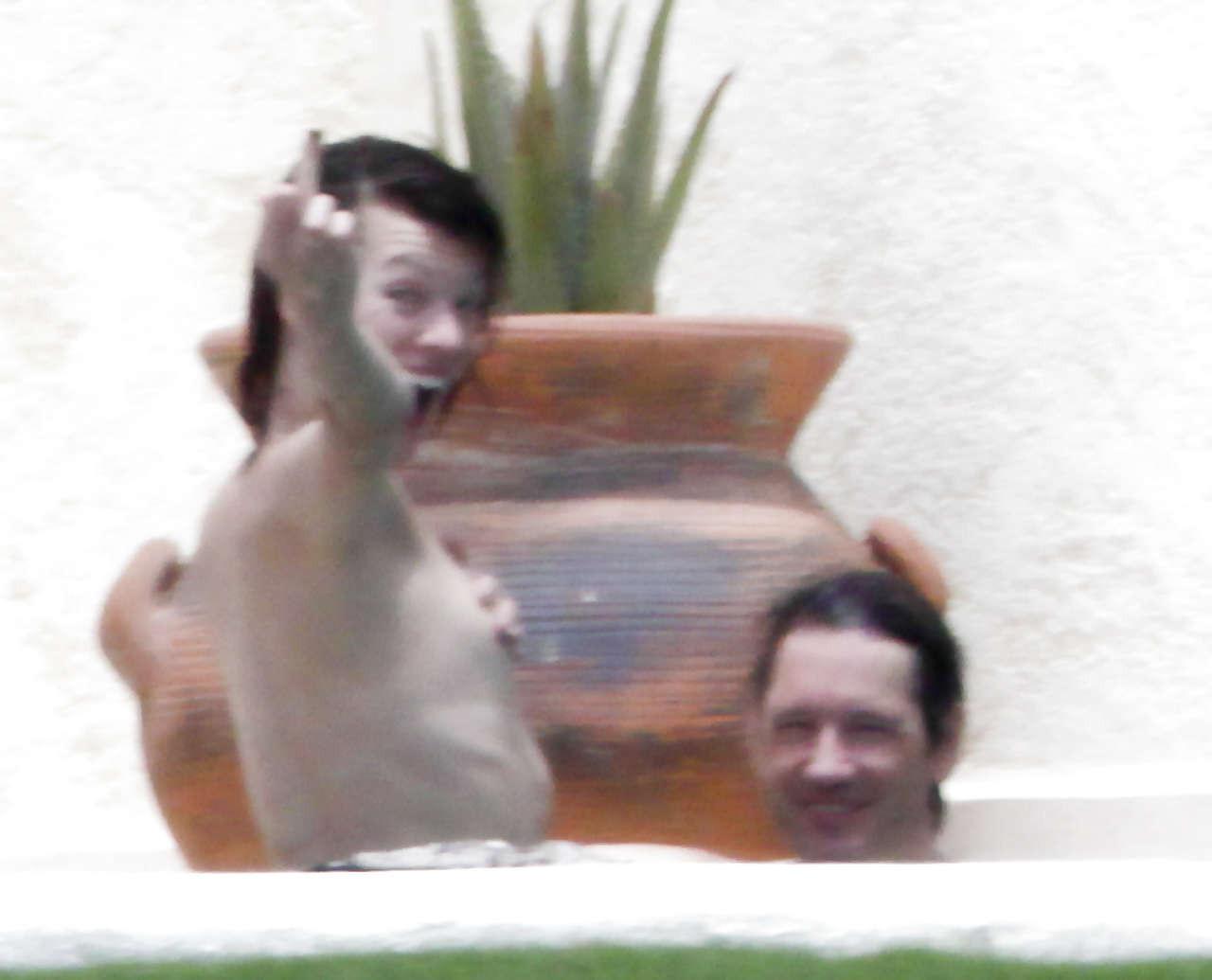 16P Milla Jovovich caught topless in pool by paparazzi and giving them middle finger