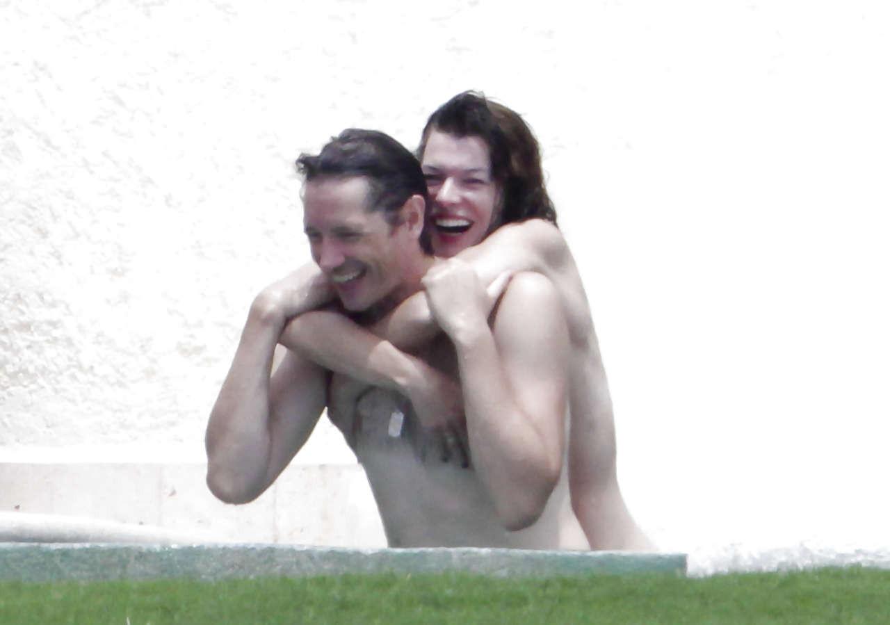 16P Milla Jovovich caught topless in pool by paparazzi and giving them middle finger