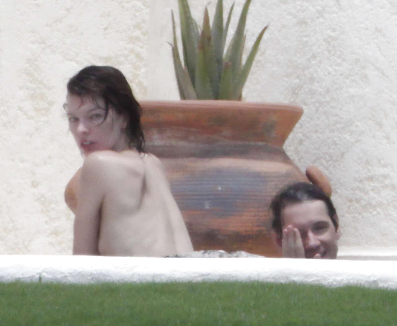 16P Milla Jovovich caught topless in pool by paparazzi and giving them middle finger