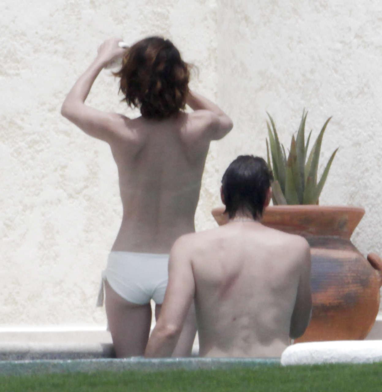 16P Milla Jovovich caught topless in pool by paparazzi and giving them middle finger