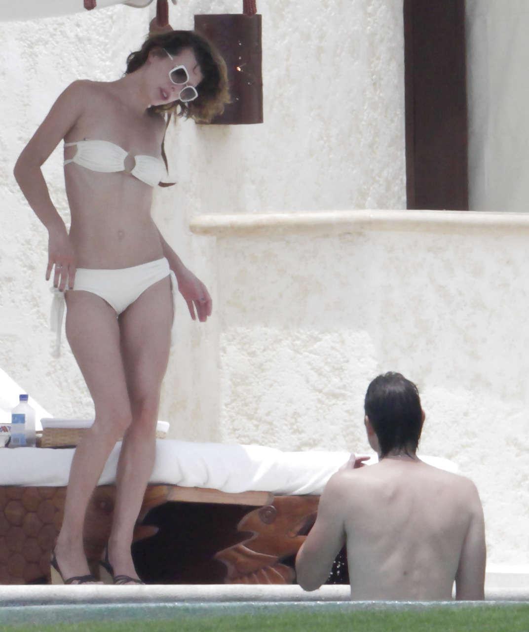 16P Milla Jovovich caught topless in pool by paparazzi and giving them middle finger