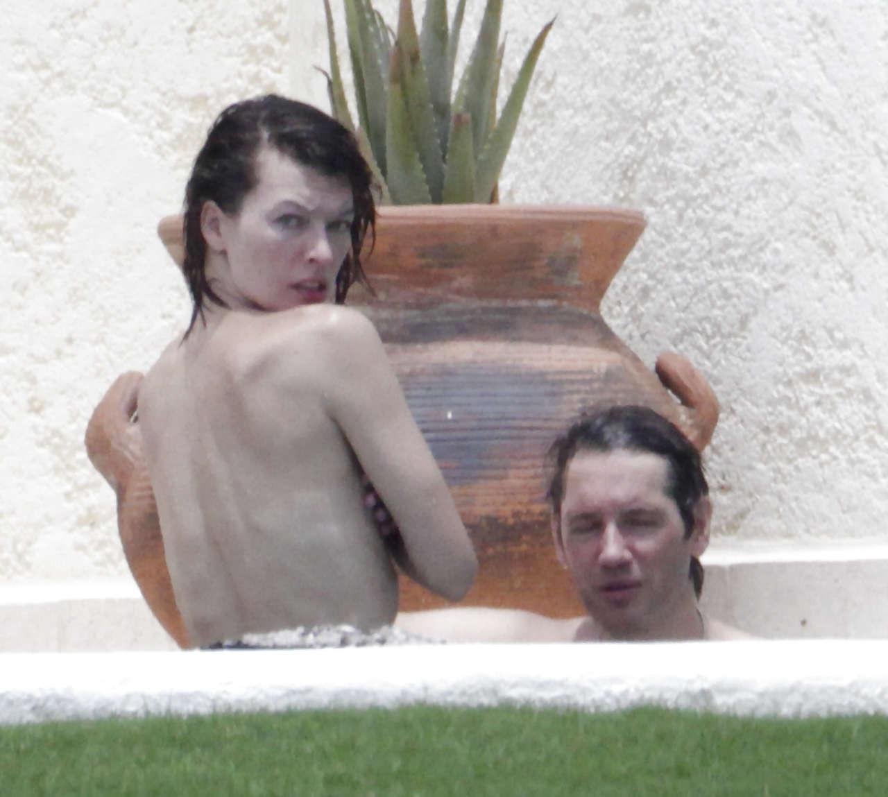 16P Milla Jovovich caught topless in pool by paparazzi and giving them middle finger