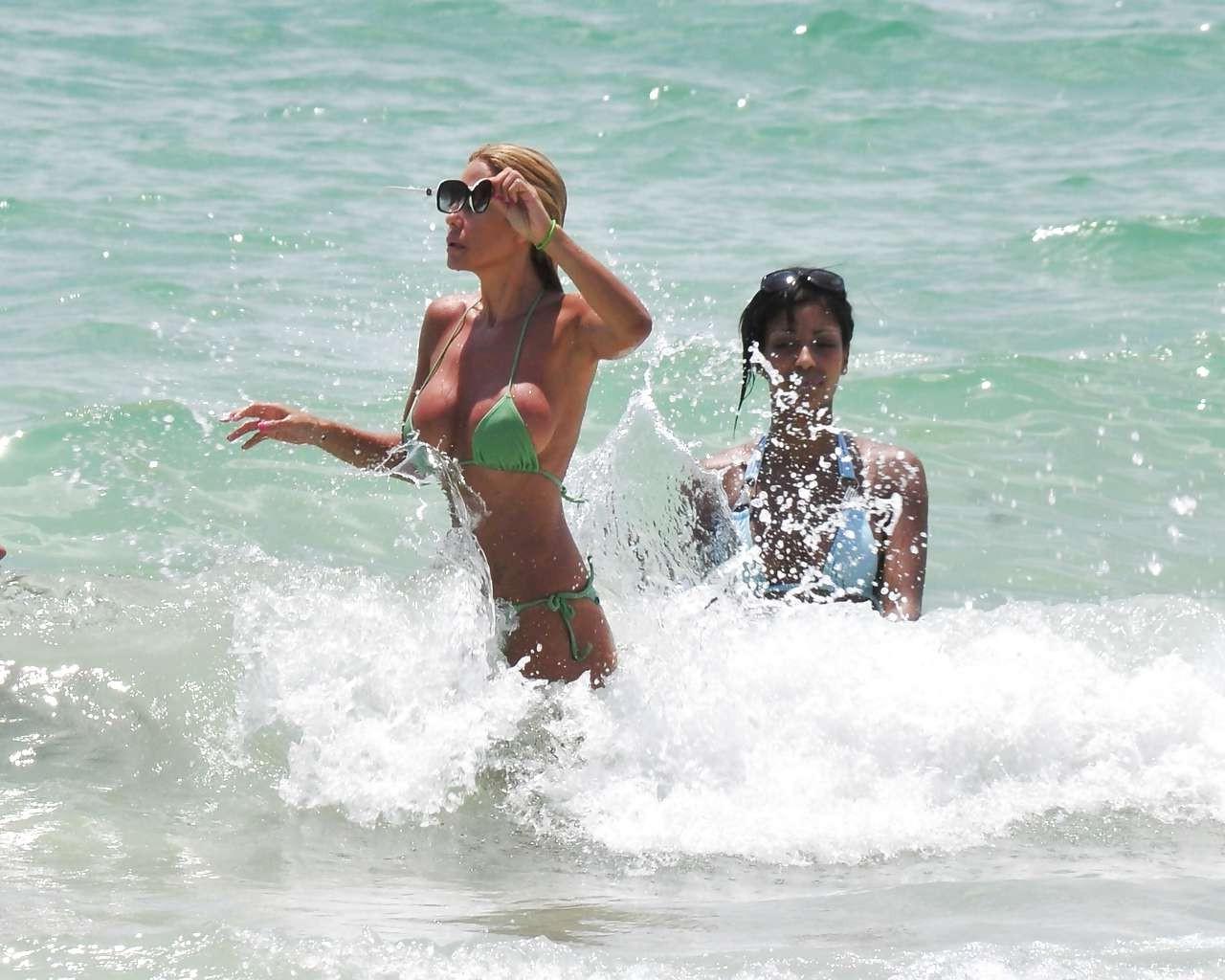 16P Shauna Sand showing her great ass in tiny green bikini caught on beach