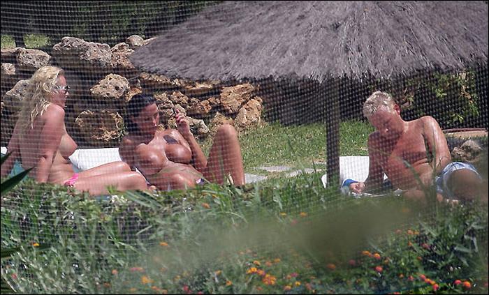 15P Katie Price caught topless while she sunbathing