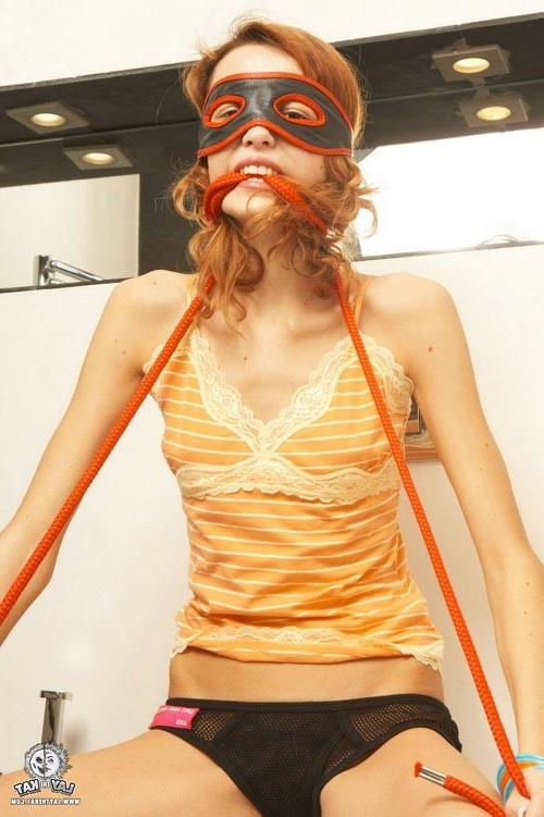 17P Young small titted redhead lady in a mask showing hot striptease
