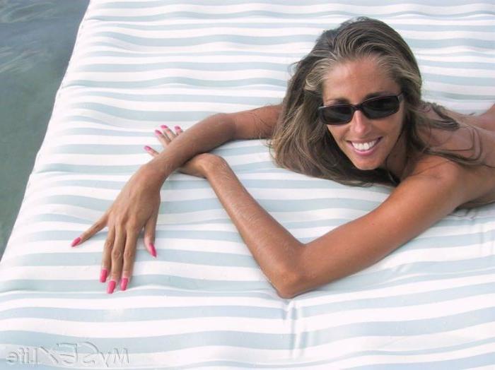 16P Lori Anderson floats naked on a raft at the nude beach