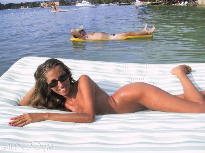 16P Lori Anderson floats naked on a raft at the nude beach