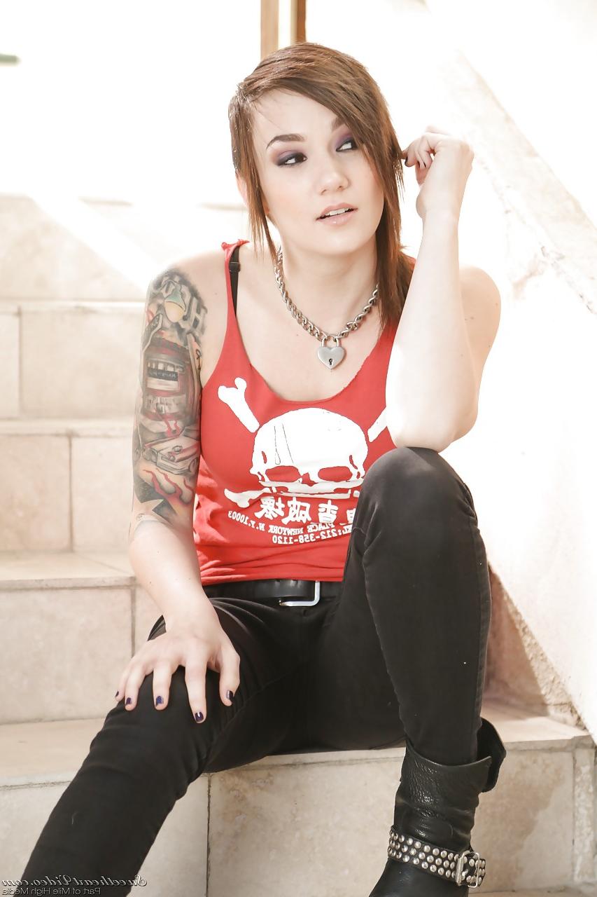 15P Tattooed erotic model Nikki Hearts undressing to pose naked on front steps